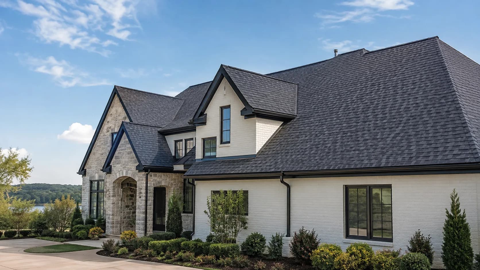 Large stone-and-siding home with a dark shingle roof